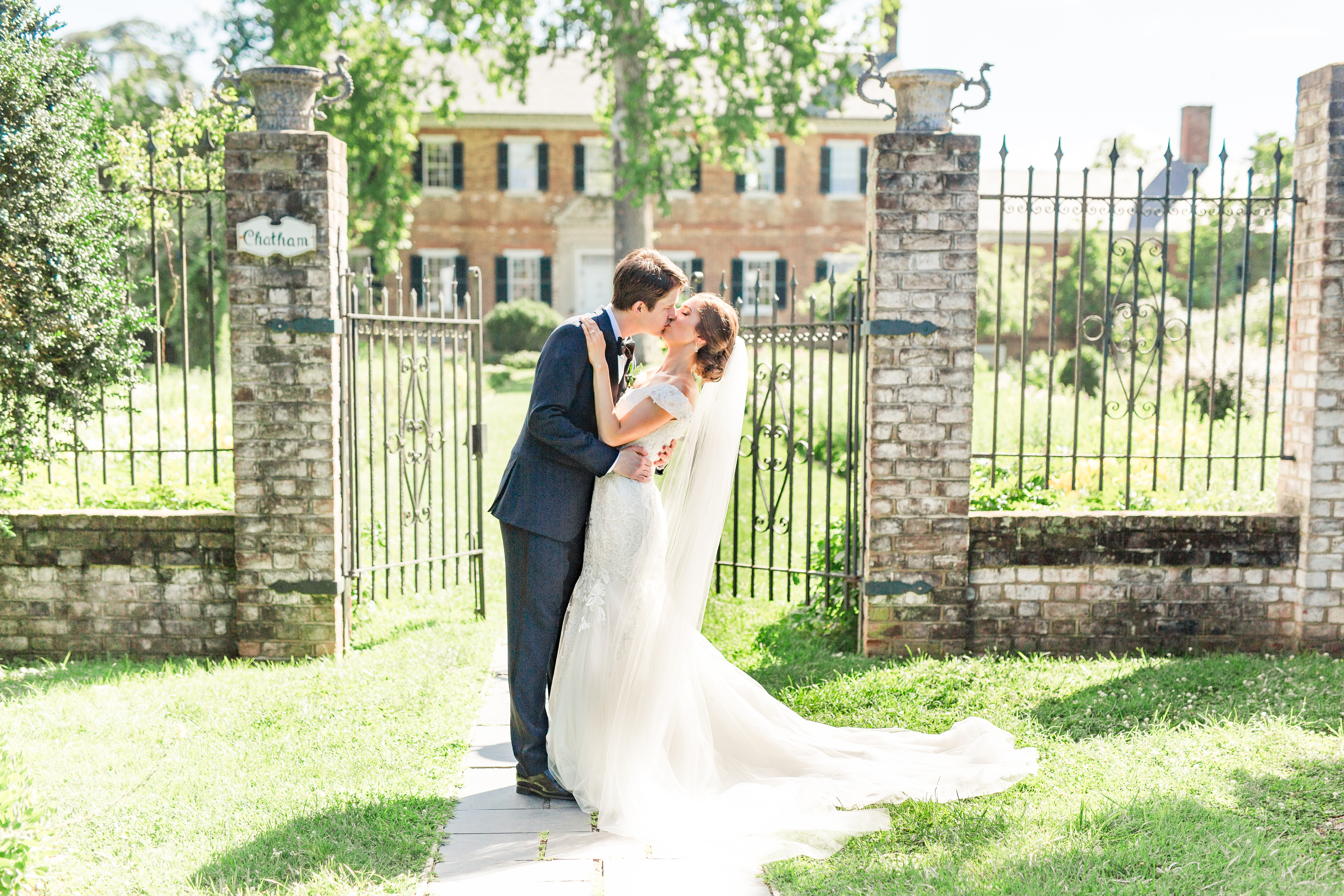 Bride and groom portraits at Chatham Manor by the front of the house near the gate