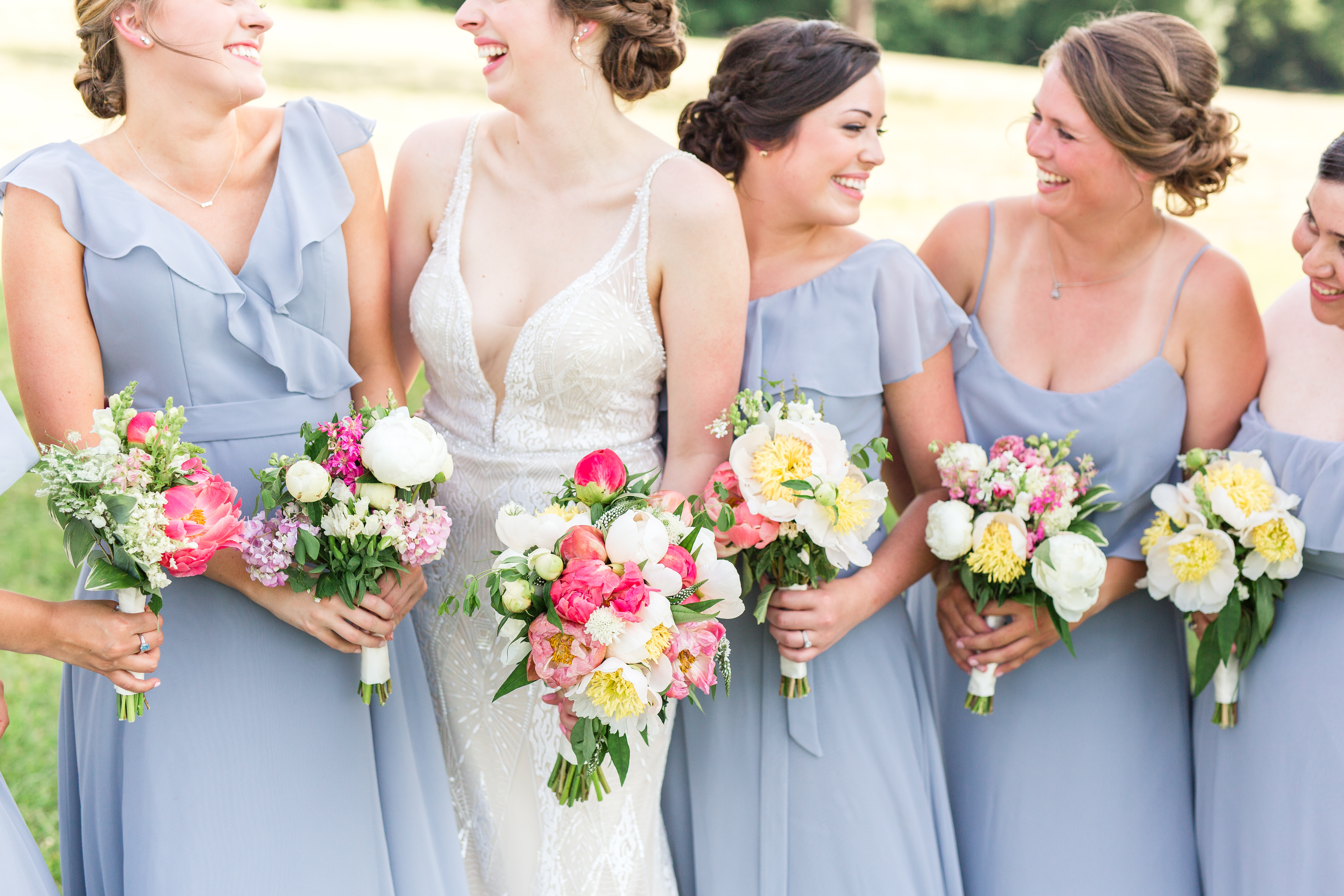 Bride and Bridesmaids in gray blue dresses with farm flowers