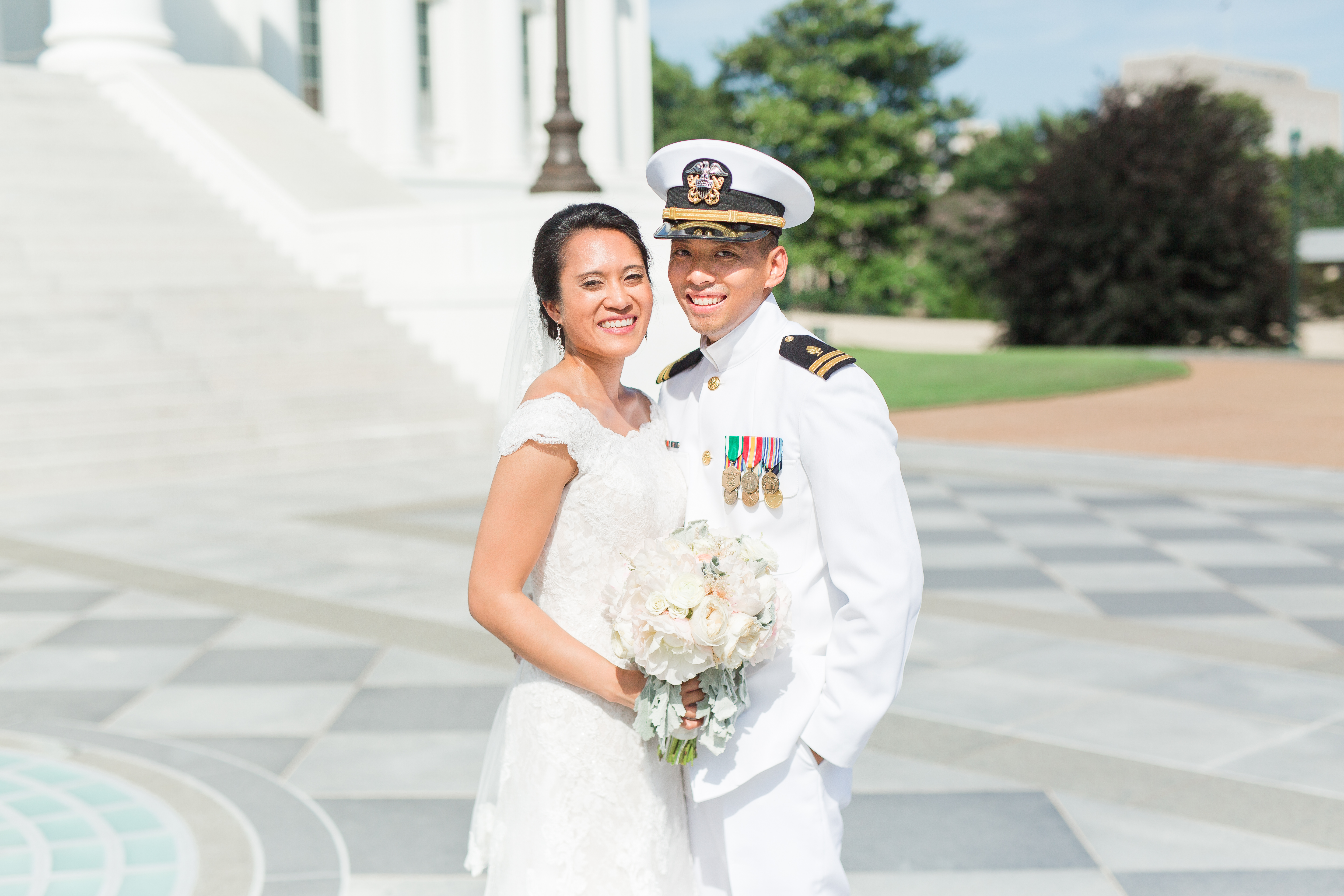 Bride and groom arm in arm at the virginia state capitla